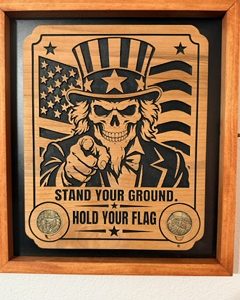 Wooden plaque showing a skeleton Uncle Sam pointing forward against an American flag, with two engraved coins and the words “Stand Your Ground. Hold Your Flag.”