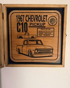 Rustic wooden shadow box with engraved 1967 Chevrolet C10 pickup artwork and lettering, plus one brass coin.